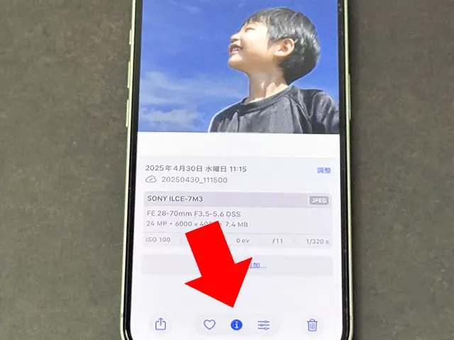 iPhoneの写真アプリで下部中央の画像を調べるボタン（[i]など）をタップ